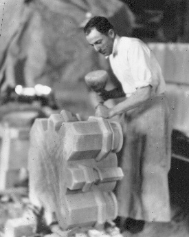 Working with mallet and chisel in the stone shed, on the sandstone base of a nave column.