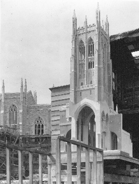 A model of the tower, so finished in appearance that in photographs that isolate it from  its surroundings it might be mistaken for the finished tower . . . until one notices the variations in windows and other design features placed side by side for comparison. Behind are the chancel and sanctuary, with windows yet unglazed.