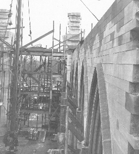 Another view of the nave clerestory wall looking toward the tower piers thrusting upward with interleaving courses. Not only is the subtle curve in plan visible along this south wall; the bend upward in elevation and then down toward the tower is strikingly shown in the differing apexes of the window arches, especially when seen against the courses of the wall.